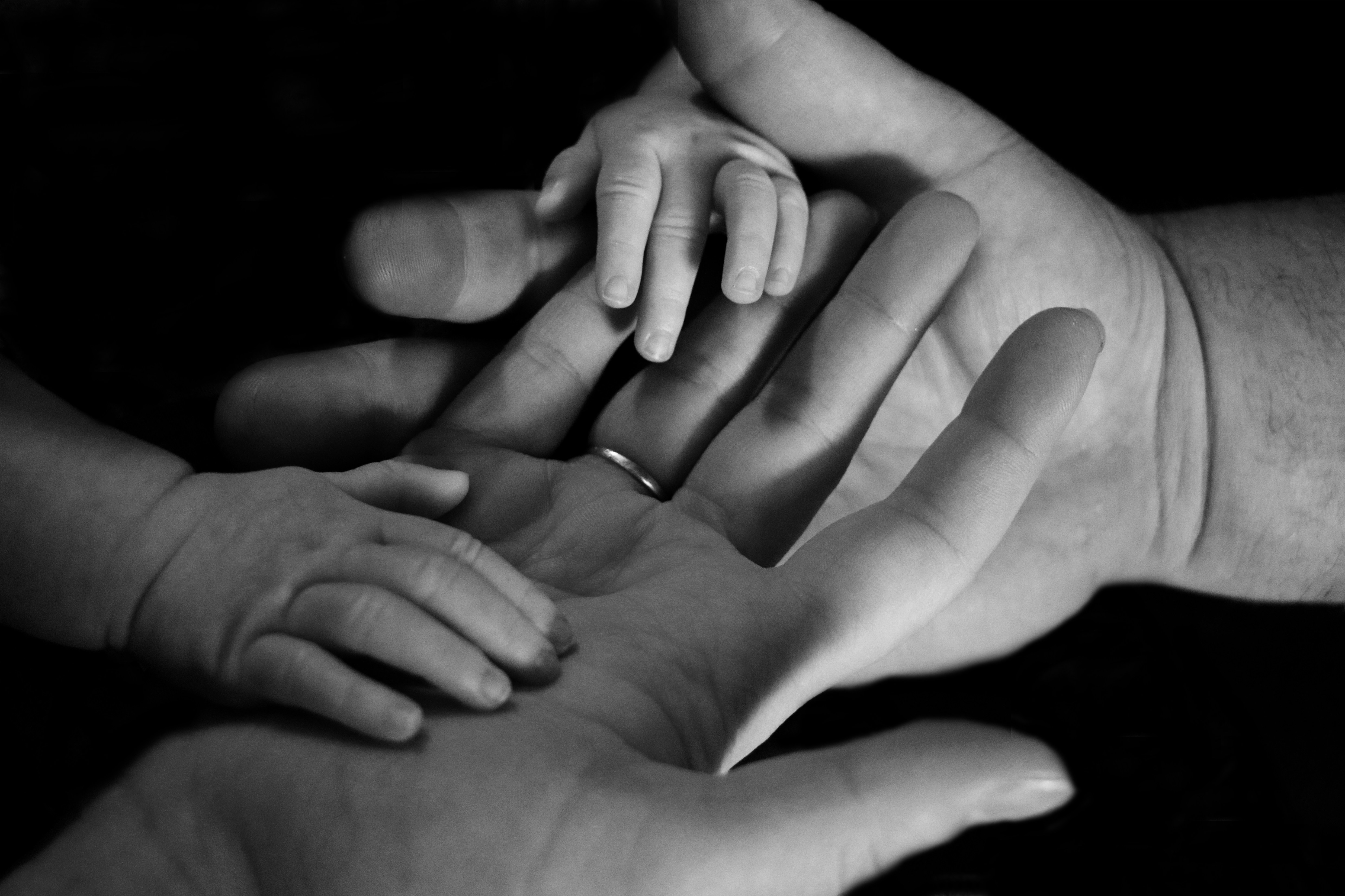 A child's hands resting on an adult caregiver's hand.